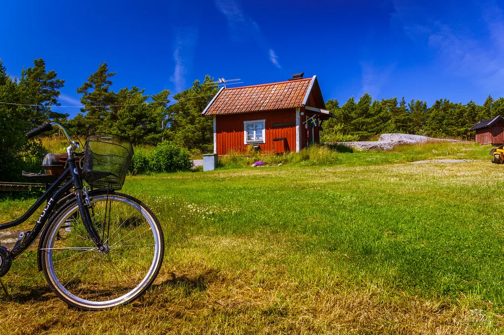 A bicycle by a red cottage in the Stockholm archipelago.